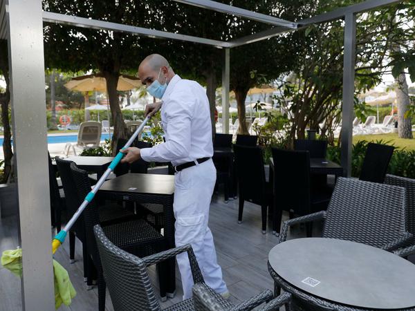 Ein Arbeiter reinigt die Terrasse des Hotels Riu Festival in Palma de Mallorca.