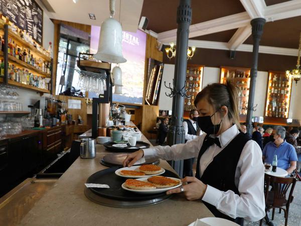 Kellnerin Diana serviert ein Frühstück in der Bar Cristal auf Mallorca.