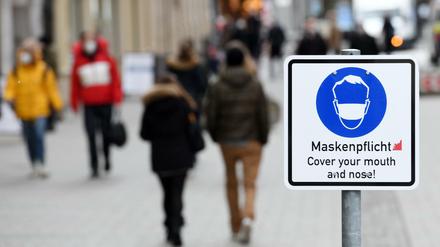 Ein Schild weist in der Münchner Innenstadt auf die Maskenpflicht hin.
