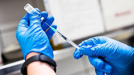 Ein Mitarbeiter eines Impfzentrums zieht eine Spritze mit dem Corona-Impfstoff Nuvaxovid des US-Herstellers Novavax auf (Symbolbild).