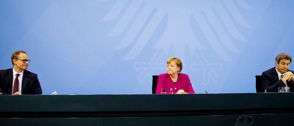 Angela Merkel (M, CDU), Markus Söder (r, CSU) und Michael Müller (SPD) nehmen nach einem Treffen im Kanzleramt an einer Pressekonferenz teil.