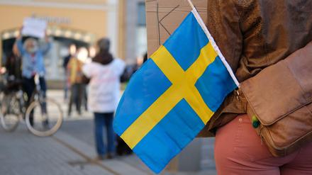 Eine Teilnehmerin einer Coronaleugner-Demonstration mit einer schwedischen Flagge.