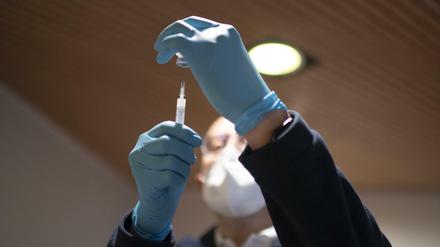 Ein Mitarbeiter bereitet eine Corona-Impfung vor (Symbolbild).