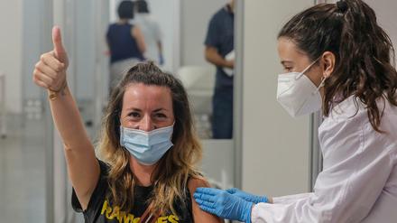 Eine junge Frau hebt in Valencia, Spanien, den Daumen, nachdem sie gegen das Coronavirus geimpft wurde.