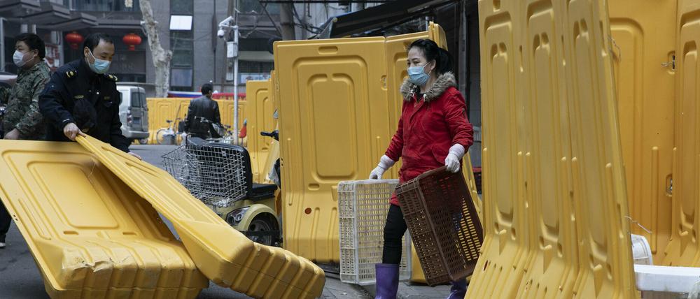 Ein Stadtarbeiter beseitigt Barrieren, die in Wuhan dazu dienten, eine Gemeinde abzuschotten.