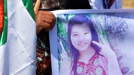 Ein Demonstrant trägt ein Plakat mit einem Foto von Mya Thwate Thwate Khaing.