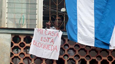 Regime-Kritiker Yunior Garcia steht an seinem verhängten Fenster.