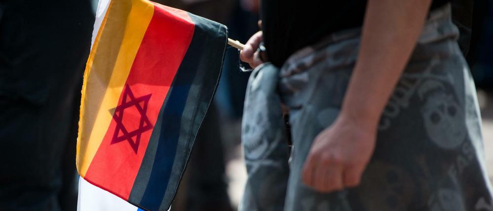 Ein Demonstrant der islamfeindlichen Pegida-Bewegung hält eine Deutschland- und eine Israel-Flagge in der Hand. 