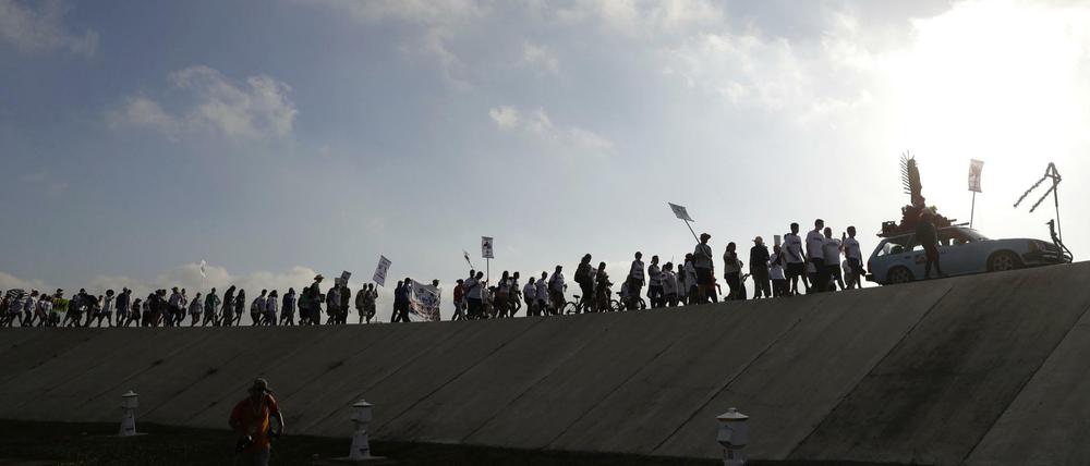 Menschen marschieren am 12.08.2017 am Rio Grande in Mission (Texas, USA) entlang. Sie protestieren gegen die von der US-Regierung geplanten Mauer an der Grenze zwischen Mexiko und USA.