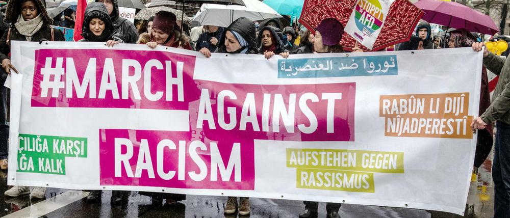 Demonstranten stehen mit einem Transparent am Start der Demonstration "Gemeinsam gegen Rassismus und Faschismus".