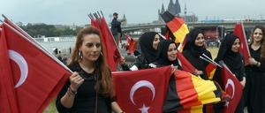 Für die Türkei und für Deutschland: Helferinnen verteilen vor dem Beginn der Kundgebung Fahnen.