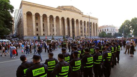 Die Polizei beobachtet Demonstranten, die sich vor dem georgischen Parlamentsgebäude in Tiflis versammeln.