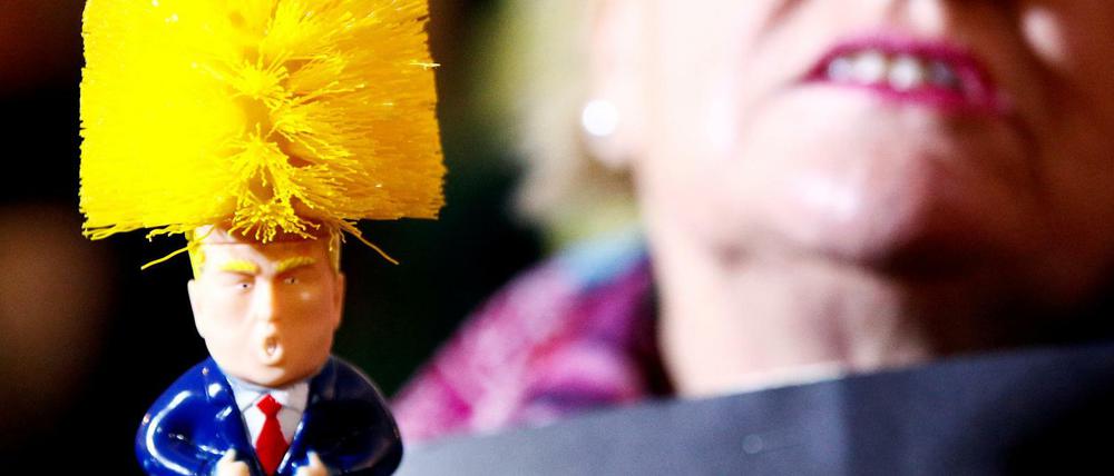 Mit einer Trump-Klobürste protestiert eine Frau am Rande des NATO-Gipfels am 03. Dezember in London. Der Präsident sieht wassersparende Toilettenspülungen kritisch.