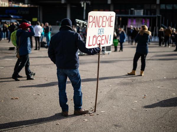 "Pandemie der Lügen!", steht auf dem Schild eines Mannes bei einer Demo gegen die Corona-Politik 