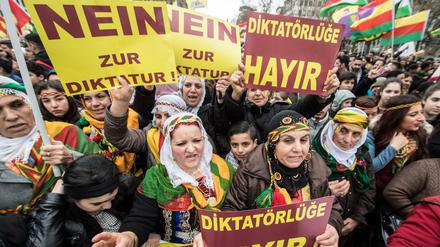 Kurdische Demonstranten gehen während einer Kundgebung zum kurdischen Frühjahrsfest Newroz am Dienstag in Frankfurt am Main mit Plakaten mit der Aufschrift "Nein zur Diktatur" durch die Innenstadt.