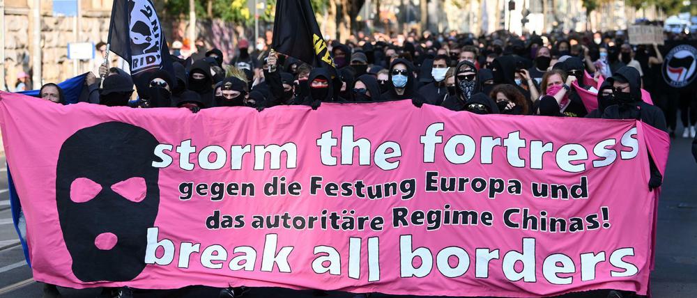 Teilnehmer der Demonstration "Storm the fortress - break all borders!" gehen durch Leipzig.