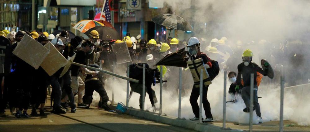  Die Demonstranten reagieren auf Tränengas während Zusammenstoßen mit Polizisten.