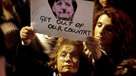 Bei einer Demonstration in Nikosia wird ein Bild von Bundeskanzlerin Angela Merkel mit angemaltem Hitlerbart in die Höhe gehoben. 