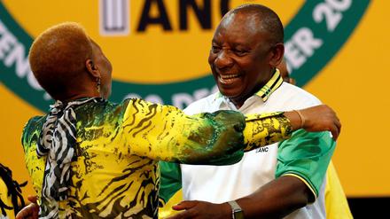 Cyril Ramaphosa (rechts) wird von einem ANC-Mitglied in den Arm genommen.