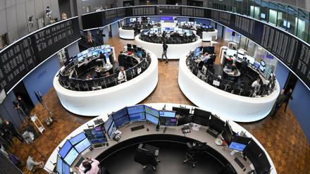 Börsenhändler sitzen im Handelssaal der Frankfurter Wertpapierbörse an ihren Arbeitsplätzen.
