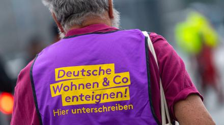 Ein Teilnehmer einer Demonstration in Berlin trägt eine Weste mit der Aufschrift "Deutsche Wohnen Co enteignen!"