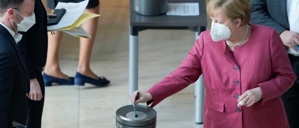 Bundeskanzlerin Angela Merkel mit Stimmkarte in der Hand bei der namentlichen Abstimmung zum neunen Infektionsschutzgesetz und Bevölkerungsschutzgesetz.