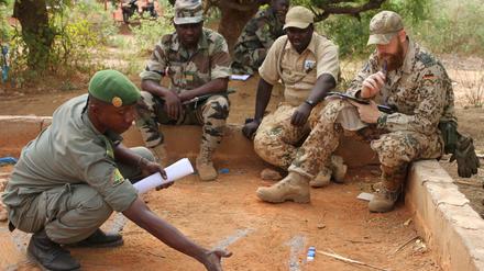 Malische Soldaten besprechen sich mit einem Ausbilder der Bundeswehr.
