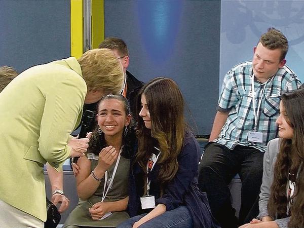 Bundeskanzlerin Angela Merkel (CDU) beugt sich am 15.07.2015 während eines Bürgerdialogs zu dem weinenden palästinensischen Mädchen Reem.