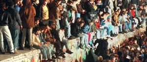 November 1989: Jubelnde Menschen auf der Berliner Mauer