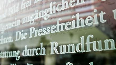 Das Wort Pressefreiheit in einem Ausschnitt des Artikels 5 des Grundgesetzes auf einer Glasscheibe am Außenhof eines Parlamentsgebäudes in Berlin. 