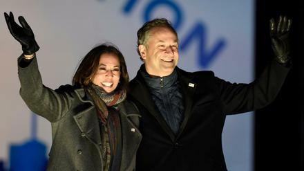 Kamala Harris und ihr Ehemann Doug Emhoff winken Unterstützern während einer Wahlkampfveranstaltung.