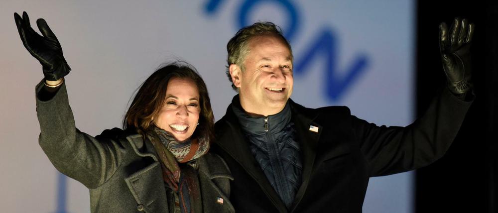Kamala Harris und ihr Ehemann Doug Emhoff winken Unterstützern während einer Wahlkampfveranstaltung.