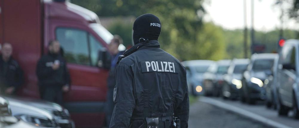 Spezialeinsatzkräfte des Landeskriminalamtes stehen vor einem Haus bei Neubrandenburg. 