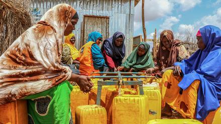 Frauen, die durch die Dürre vertrieben wurden, stehen im Lager Kaam Jiroon für Binnenvertriebene Schlange, um Wasserbehälter zu füllen. Eine beispiellose vierte ausgebliebene Regenzeit mit katastrophalem Hunger, Krankheit und Vertreibung hat Somalia in eine Krise gezwungen.
