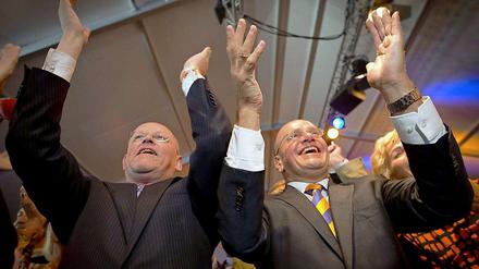 Die Minister Uri Rosenthal (l.) und Fred Teeven von der rechtsliberalen Partei VVD feiern nach der Bekanntgabe der ersten Wahlbefragungen.