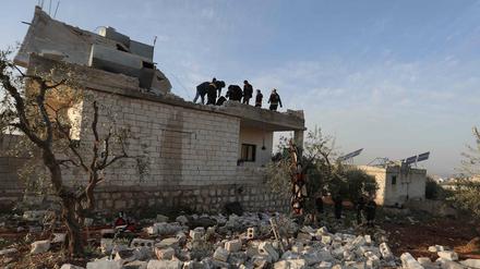 Menschen versammeln sich auf dem zerstörten Haus, in dem der ehemalige IS-Anführer Abu Ibrahim al-Hashimi al-Qurashi starb.