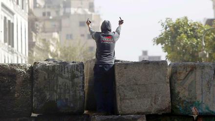 Ein junger Demonstrant klettert in Nähe des Kairoer Tahrirplatzes auf ein Bollwerk: Zum zweiten Jahrestag der Revolution kommt es zu Ausschreitungen gegen die Mursi-Regierung