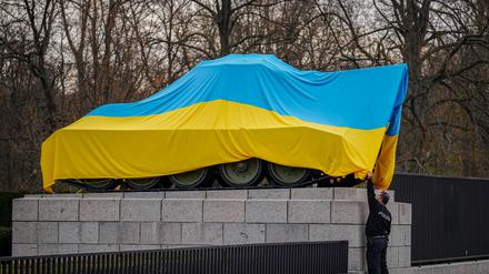 Polizeibeamte entfernen eine ukrainische Flagge von einem Panzer am Sowjetischen Ehrenmal (am 30. März 2022)