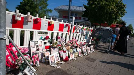 Bilder, Briefe und Blumen liegen in München in der Nähe des Olympia-Einkaufszentrum (OEZ) an einem eingezäunten Bereich auf dem Gehweg.