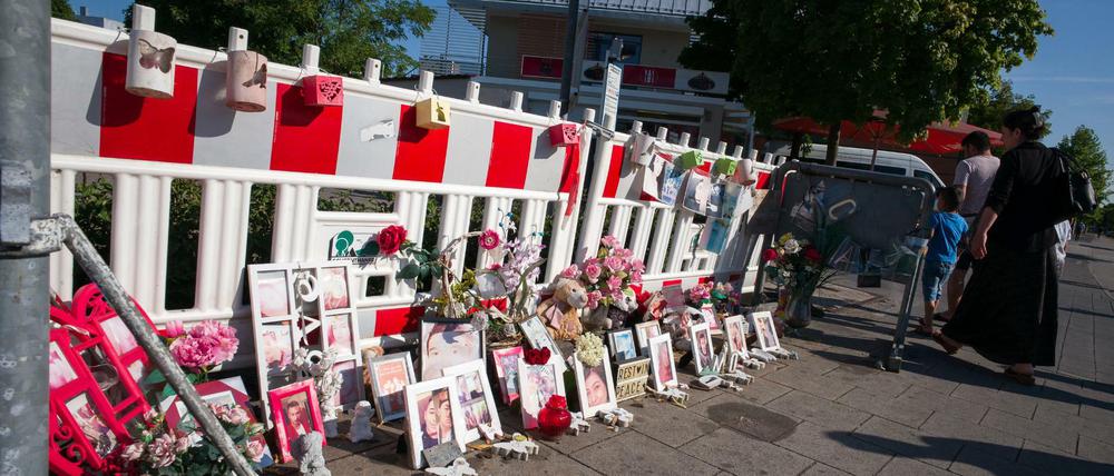 Bilder, Briefe und Blumen liegen in München in der Nähe des Olympia-Einkaufszentrum (OEZ) an einem eingezäunten Bereich auf dem Gehweg.