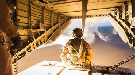 Ein Soldat der Bundeswehr sitzt bei Mazar-i-Sharif der offenen Ladefläche eines Helikopters. 