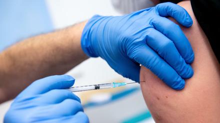 Ein Mann wird von einem Klinikmitarbeiter mit dem Corona-Impfstoff von Biontech/Pfizer geimpft. 