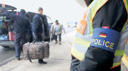 Polizisten begleiten abgelehnte Asylbewerber aus Tunesien auf dem Flughafen Leipzig-Halle.