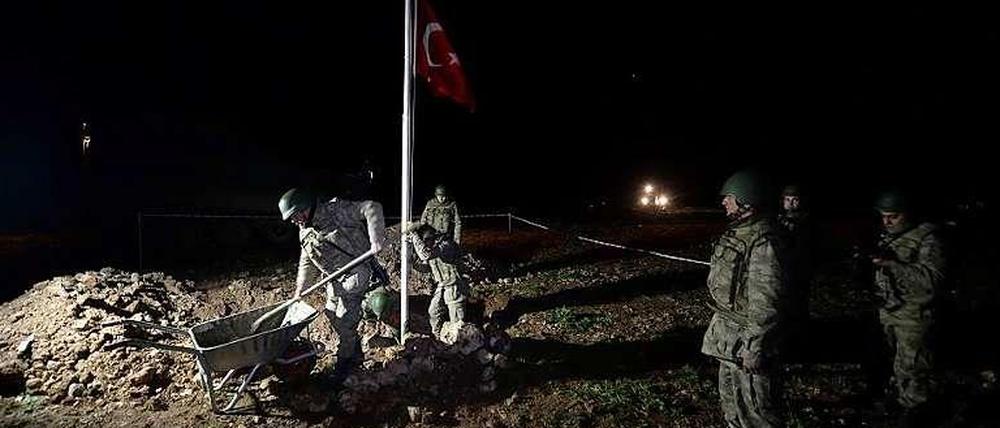 Soldaten stellen eine türkische Flagge auf dem neuen Grab von Suleyman Shah auf.