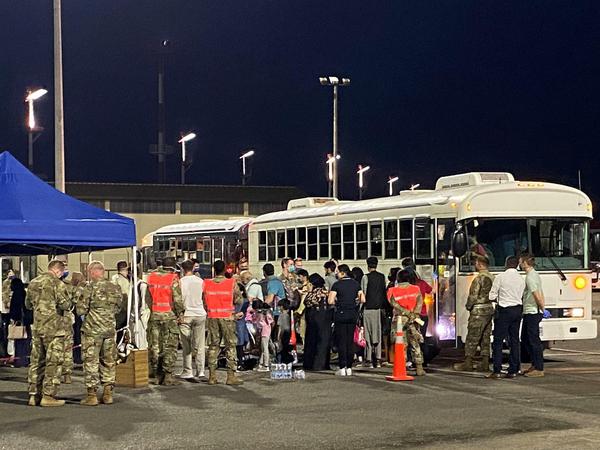 Evakuierte werden in Bussen zum Hangar gebracht.