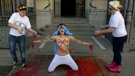 Mit nackten Brüsten kniet am 23. Dezember eine Aktivistin der Frauenrechtsgruppe Femen vor einer Kirche in der Hauptstadt Madrid. Auf Oberkörper und Arme hatte sie die Slogans „Weihnachten ist abgesagt“ und „Freie Abtreibung“ geschrieben.