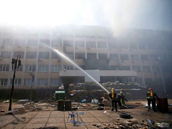 Feuerwehrleute löschen einen Brand im besetzten Rathaus von Mariupol im Südosten der Ukraine. 
