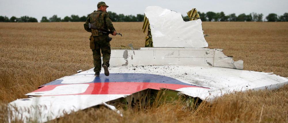 Ein prorussischer Separatist steht auf einem Wrackteil der MH17.