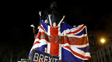 Briten feiern vor einer Statue Winston Churchills in London den Brexit.
