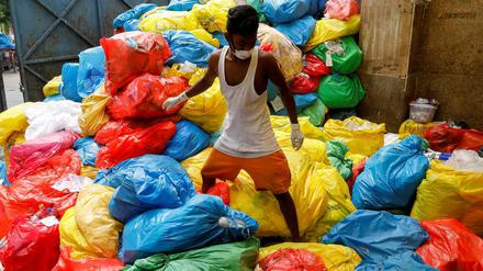 Ein Müllsammler auf einem Berg medizinischer Abfälle in Neu Dehli im Juli 2020.